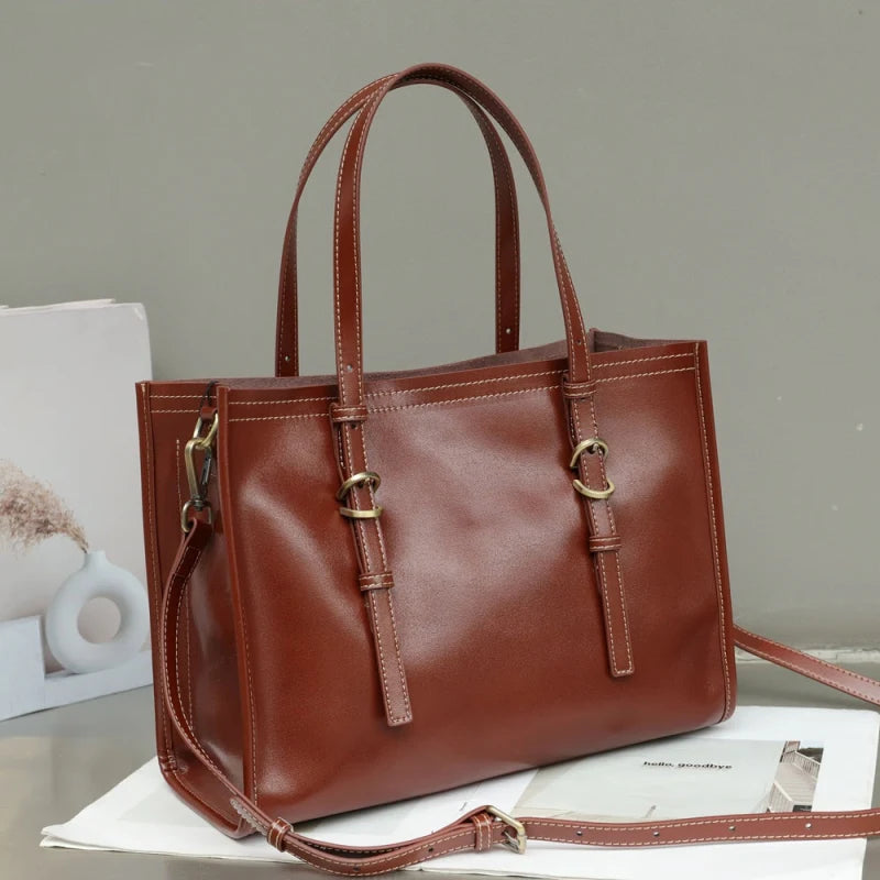 Sac tote en cuir marron posé sur table avec fond gris et décor