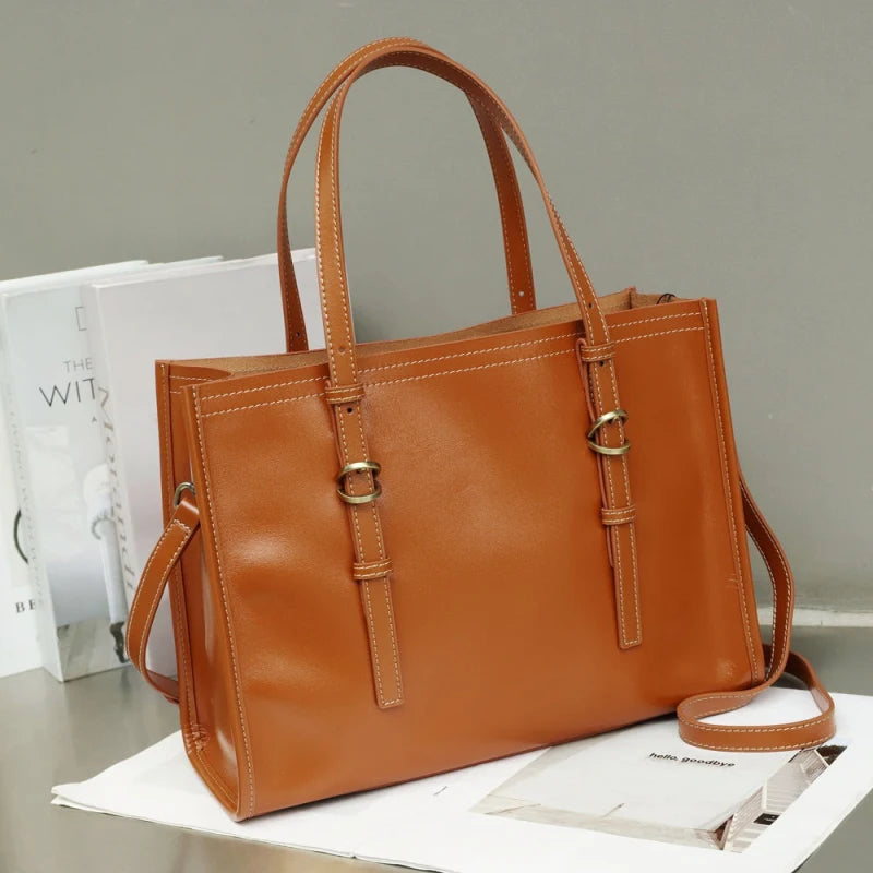 Sac tote en cuir couleur jaune posé sur table avec fonds livres blancs