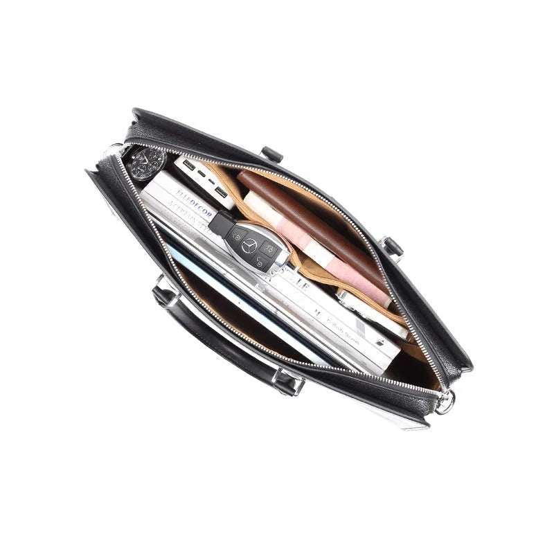 Intérieur du cartable en cuir contenant un ordinateur portable, une montre, une clé et des documents